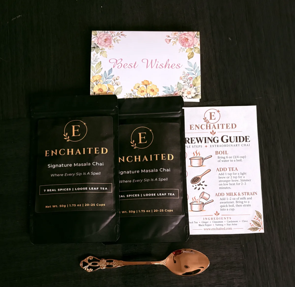 Gift box contents laid out: two masala chai pouches, Best Wishes card, brewing guide and gold teaspoon